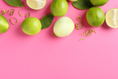 Lime zest, leaves and fresh fruits on pink background. Space for textの写真素材