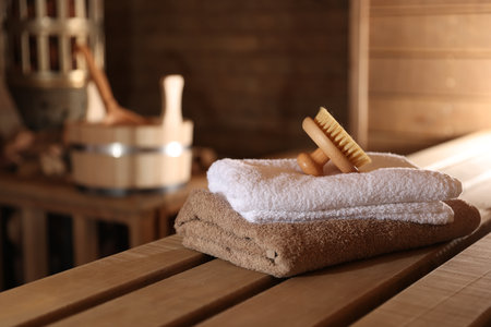 Massaging brush, stack of towels and other supplies in saunaの写真素材