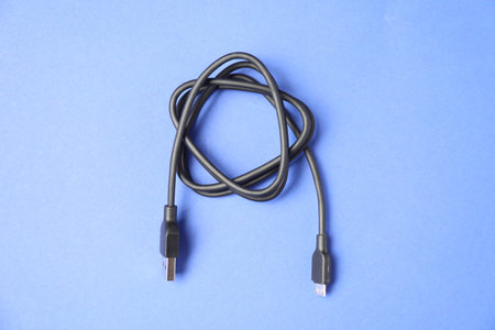One USB charge cable on blue background, top view