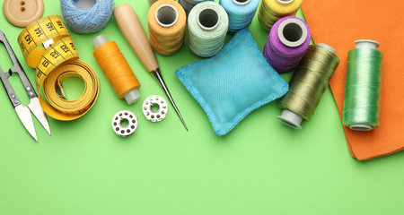Different sewing supplies on green background, flat lay. Space for textの写真素材