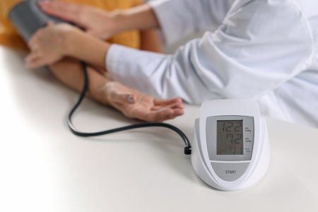 Doctor measuring senior woman's blood pressure at table, closeupの写真素材