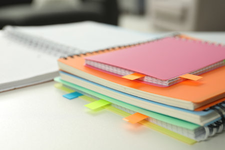 Notebooks with colorful tabs on light table, closeupの写真素材