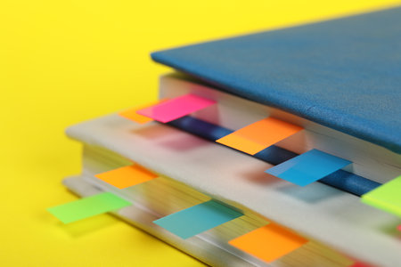Books with colorful tabs on yellow background, closeupの写真素材