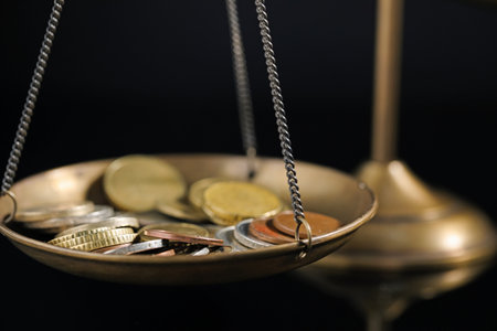 Many coins on scales against black background, closeupの写真素材