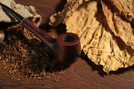 Tobacco, dried leaves and smoking pipe on wooden table, closeupの写真素材