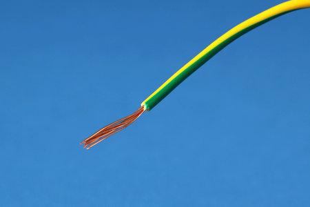 Stripped electrical wire on blue background, closeup