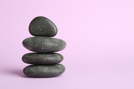 Stack of rocks on lilac background, space for text. Harmony and life balanceの写真素材
