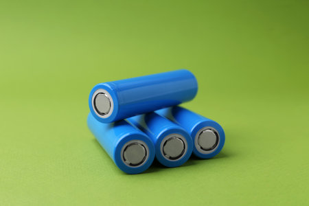 Many cell batteries on green background, closeup. Space for textの写真素材