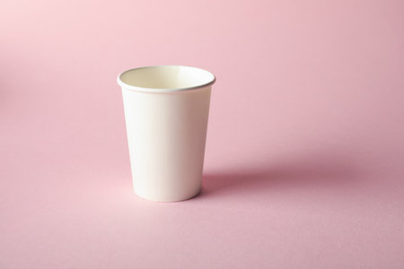 One paper cup on pink background. Mockup for designの写真素材