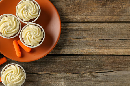 Carrot muffins and fresh vegetables on wooden table, flat lay. Space for textの写真素材