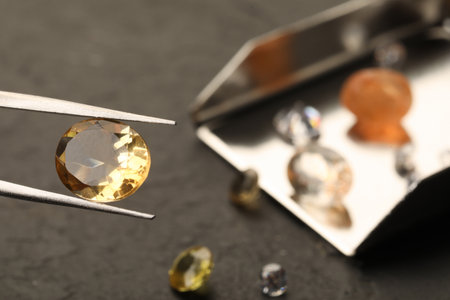 Tweezers with beautiful gemstone on blurred background, closeupの写真素材