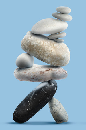 Balance shown as stacked stones on light blue backgroundの写真素材