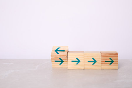 Wooden cubes with blue arrows on tableの写真素材