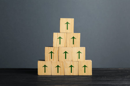 Cubes with green arrows on black wooden table against gray background