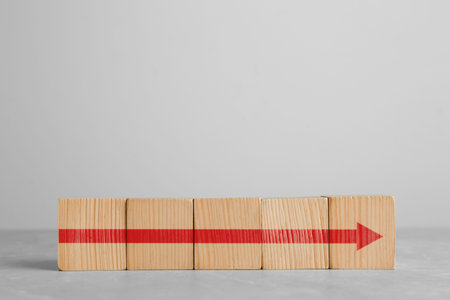 Red arrow made of cubes on light background