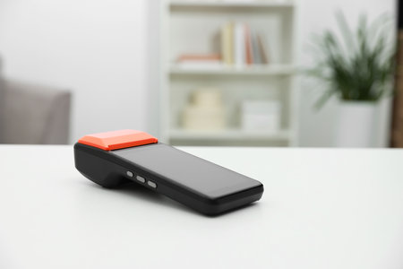 Payment terminal on white table indoors, closeup. Space for textの写真素材
