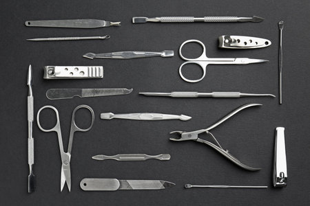 Set of pedicure tools on black background, flat lay