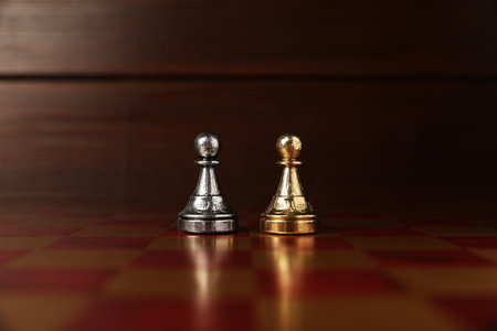 Golden and silver pawns in middle of chessboard. Competition conceptの写真素材