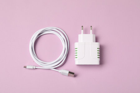 USB power adapter and charge cable on pink background, flat layの写真素材