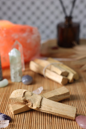 Palo santo sticks and gemstones on bamboo mat, closeupの写真素材