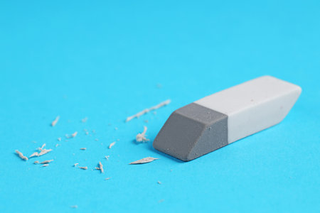 One eraser and scraps on light blue background, closeupの写真素材