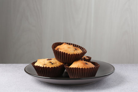 Delicious muffin with chocolate chips on light grey tableの写真素材