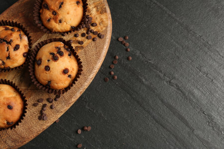 Delicious muffin with chocolate chips on black table, top view. Space for textの写真素材