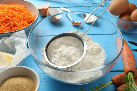Different ingredients for making carrot cake on light blue wooden table, closeupの写真素材