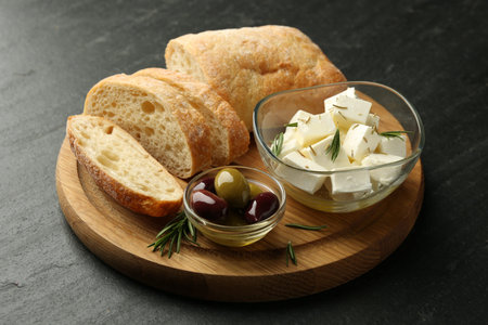 Marinated olives, bread and feta cheese served on black table, closeupの写真素材
