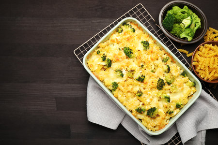 Tasty pasta casserole with cheese and broccoli on wooden table, flat lay. Space for textの写真素材