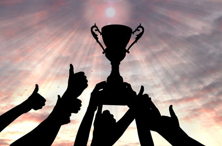 Silhouettes of woman holding trophy and people showing thumbs-up against sunset sky, closeupの写真素材