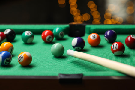 Many colorful billiard balls and cue on green table indoors, closeupの写真素材