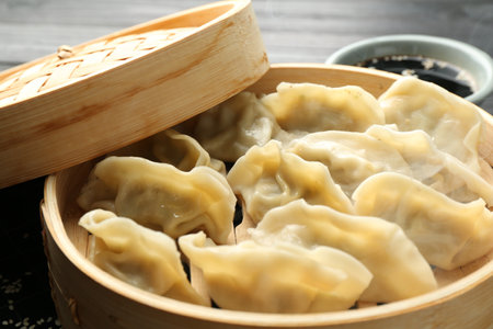 Tasty boiled gyoza (dumplings) in bamboo steamer on table, closeupの写真素材