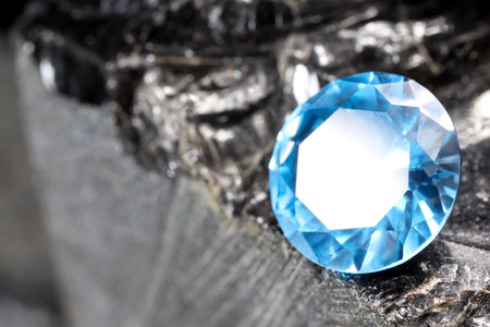 Beautiful shiny light blue gemstone on stone, closeup. Space for textの写真素材
