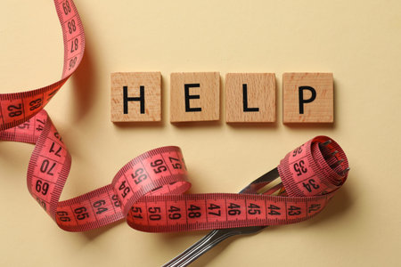 Bulimia. Word Help, fork and measuring tape on beige background, top view