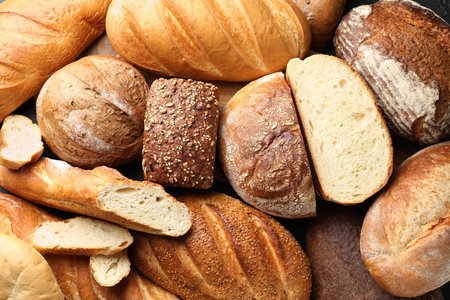 Whole and cut loafs of bread on table, closeupの写真素材