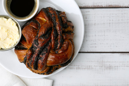 Delicious poppy seed pastry, butter and coffee on white wooden table, top viewの写真素材