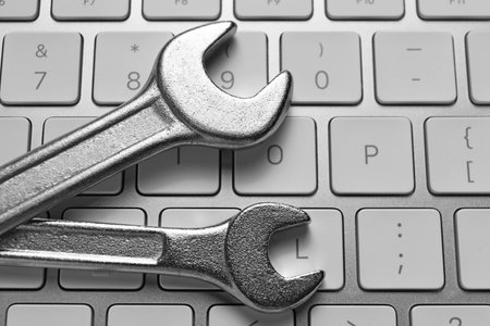 Technical support concept. Wrenches on keyboard, top viewの写真素材