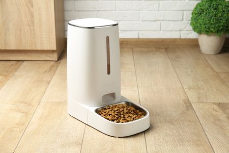 Dry pet food in automatic feeder on floor indoorsの写真素材