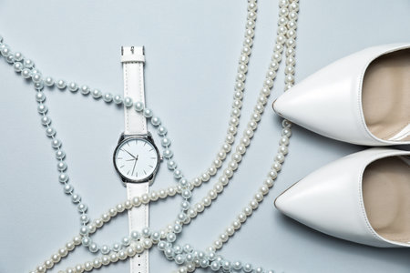 Stylish pearl necklaces, watch and shoes on light grey background, flat layの写真素材