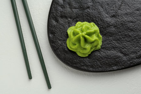 Slate board with hot wasabi paste and chopsticks on light textured table, top viewの写真素材