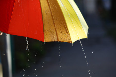 Open bright umbrella under pouring rain outdoors, closeupの写真素材