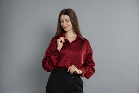 Beautiful woman in stylish outfit on grey backgroundの写真素材