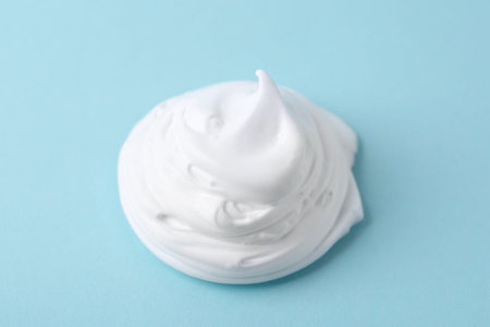 Sample of fluffy foam on light blue background, closeupの写真素材