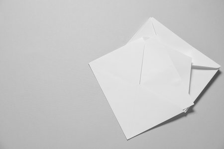 Paper envelopes with letter on gray background, top view. Mockup for designの写真素材