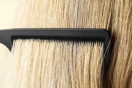 Brushing hair with plastic comb, closeup viewの写真素材