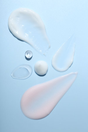 Cream and gel samples on light blue background, top viewの写真素材