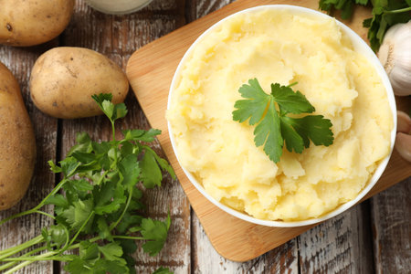 Delicious mashed potato with parsley served on wooden table, flat layの写真素材