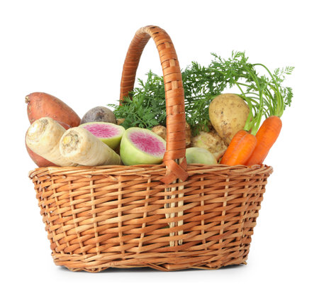 Different root vegetables in wicker basket isolated on whiteの写真素材