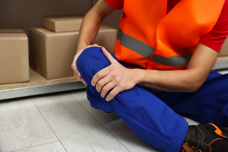 Accident at work. Injured man on floor in warehouse, closeupの写真素材